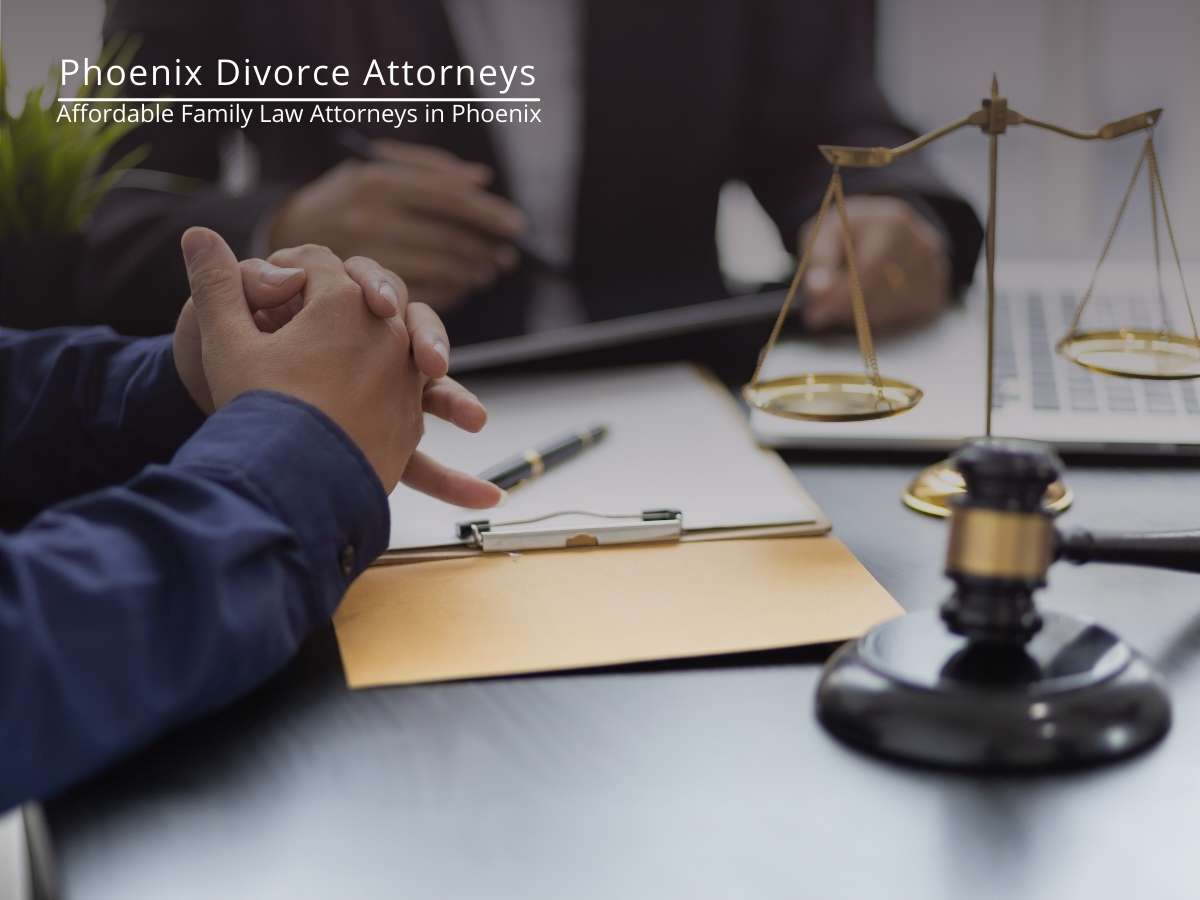 A person sitting at a desk with a lawyer, legal documents in front, a laptop, scales of justice, and a gavel, indicating a legal setting for discussing child support laws in Arizona